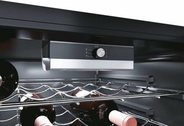 Detailweergave van de temperatuurregelaar in de Candy CWC 021 M/N wijnkoelkast, met flessen op metalen wijnrekken