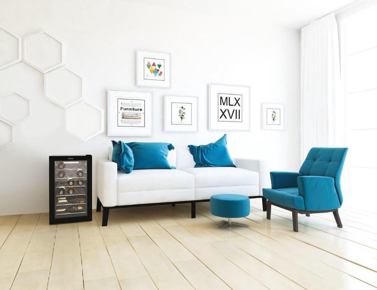Candy CWC 021 M/N wijnkoelkast in moderne woonkamer met witte bank en blauwe accenten, geschikt voor 21 flessen wijn
