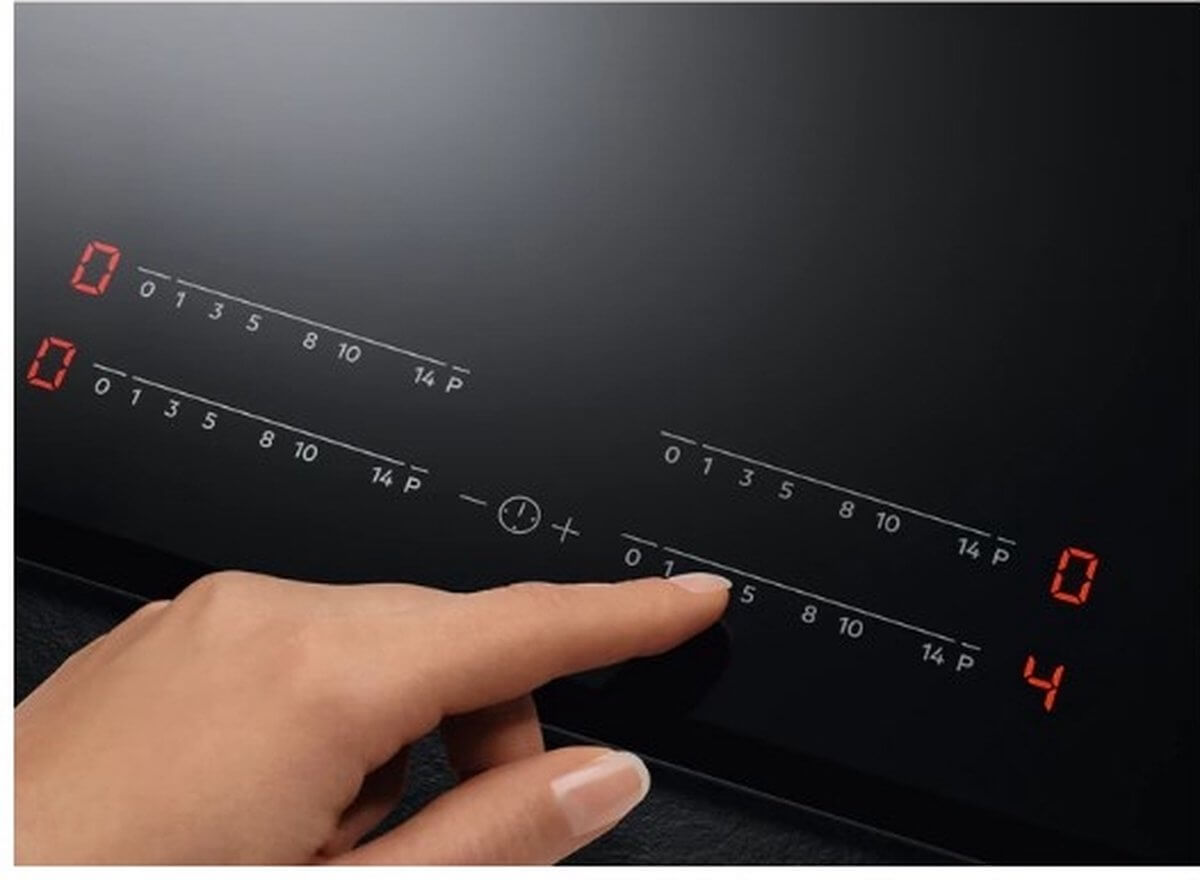Vinger bedient de rode slider-touchbediening van de AEG IKB84443IB inductiekookplaat voor nauwkeurige temperatuurregeling