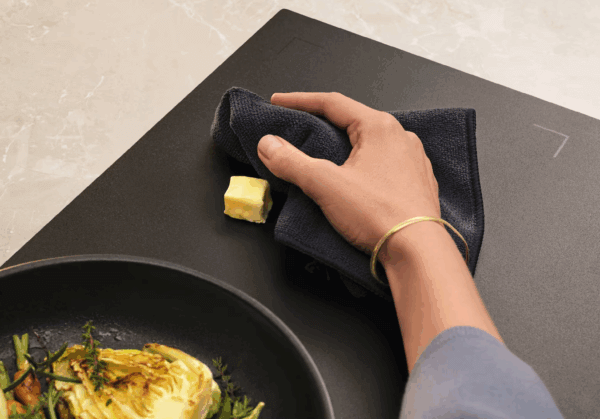 Schoonmaken van de matte Electrolux EIS87553IZ inductiekookplaat met een doek