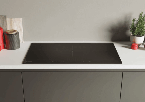 Hoover HIFS954SC inductiekookplaat in zwart glas, stijlvol ingebouwd op wit aanrechtblad