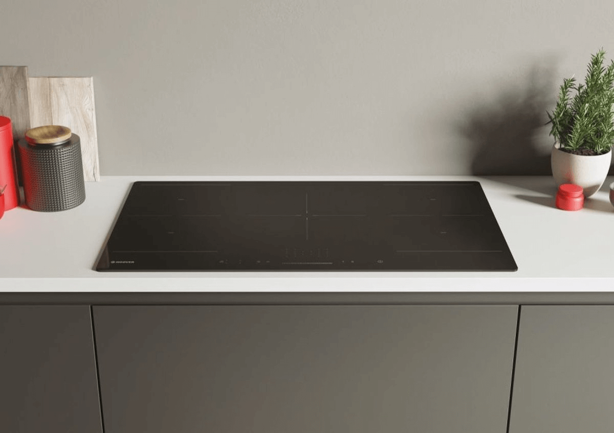 Hoover HIFS954SC inductiekookplaat in zwart glas, stijlvol ingebouwd op wit aanrechtblad