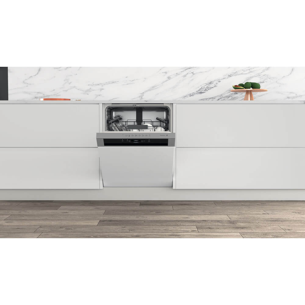 Whirlpool WB 6020 P X half-geïntegreerde inbouwvaatwasser in moderne keuken, gedeeltelijk geopend met zicht op het interieur