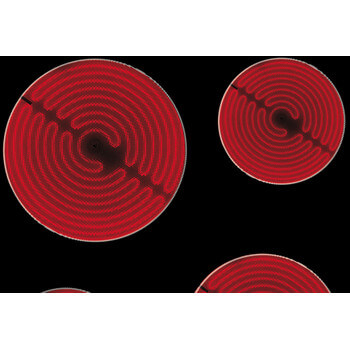 Detailopname van de rode verwarmingsspiralen van de Whirlpool AKM9010NE vitrokeramische kookplaat.