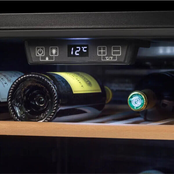 Close-up van het digitale display van de Climadiff CS105B1 wijnkoelkast met temperatuurinstelling 12 °C en flessen op houten plank